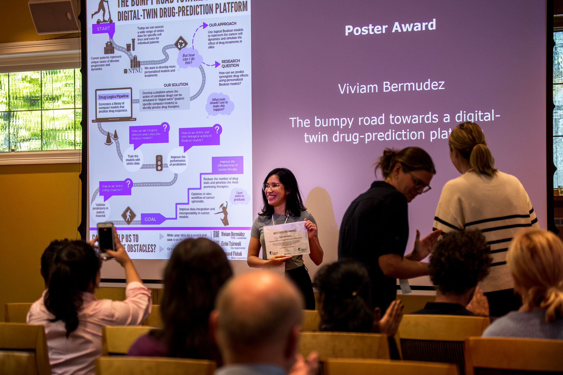 A picture of the winner of the poster award, and her poster